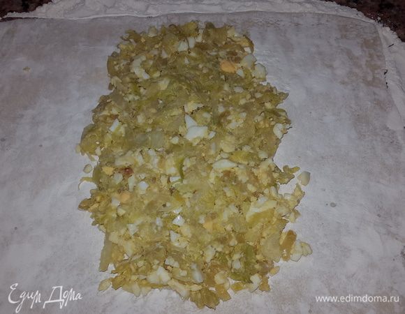 Тесто тонко раскатываем присыпая мукой и выкладываем в центр начинку оставляя края как на фото.