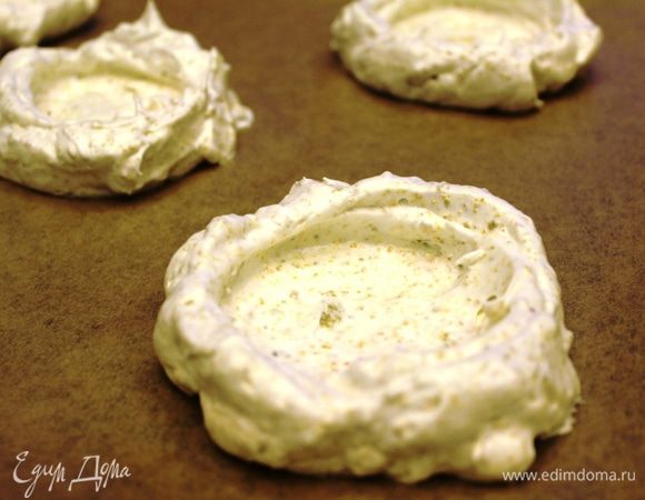 Предварительно разогреть духовой шкаф до 150 градусов в режиме конвекции. На два неглубоких противня выстелить бумагу для выпечки. Пока белковая масса держит форму постараться быстро разложить ее на противни, чтобы получилось 8 одинаковых порций. Чайной ложкой равномерно распределить массу так, чтобы получились аккуратные формочки с небольшим углублением.