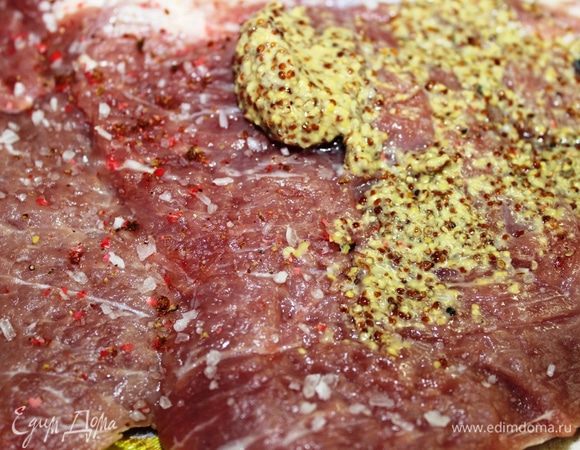 Посыпать мясо крупной солью, свежемолотым розовым перцем и смазать горчицей.