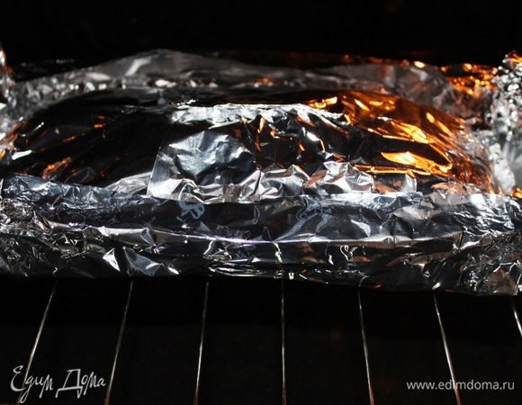 Разогреть духовой шкаф до 200 градусов в конвекционном режиме. Свернуть мясо неплотным рулетом, стараясь, чтобы начинка не вытекала. Расстелить на столе фольгу в два-три слоя, разместить в центре свернутое мясо и смазать его маслом. Накрыть сверху еще двумя слоями фольги и аккуратно защипать все края, чтобы сок не выходил (края немного приподнять как у лодочки). Уложить кулек с мясом на решетку и поставить в духовой шкаф.