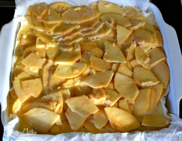 Нам потребуется огнеупорная форма для выпечки 25х25 см или 30х23 см. Пекарскую бумагу смочить в воде и как следует отжать, стряхнуть лишние капли воды и выложить бумагой форму для выпечки. Выложить яблоки и разровнять.