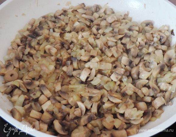 Для грибной начинки шампиньоны мелко нарезаем, выкладываем на раскаленную сухую сковороду, держим их там до испарения жидкости, затем уменьшаем огонь, добавляем растительное масло и мелконарезанный лук. Жарим до готовности лука, солим по вкусу.