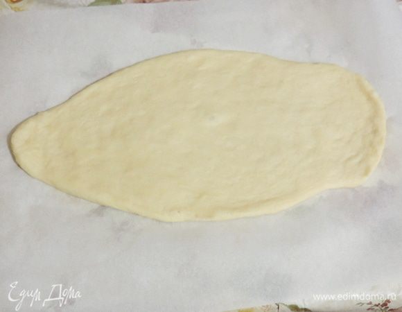 Приступаем непосредственно к формированию "рыбки". Оставляем кусочек теста размером со среднюю картофелину для оформления. Остальное делим на две почти одинаковые части. Для нижнего слоя раскатываем меньшую часть в форме капельки толщиной примерно 0,5 см. Намечаем голову рыбки.