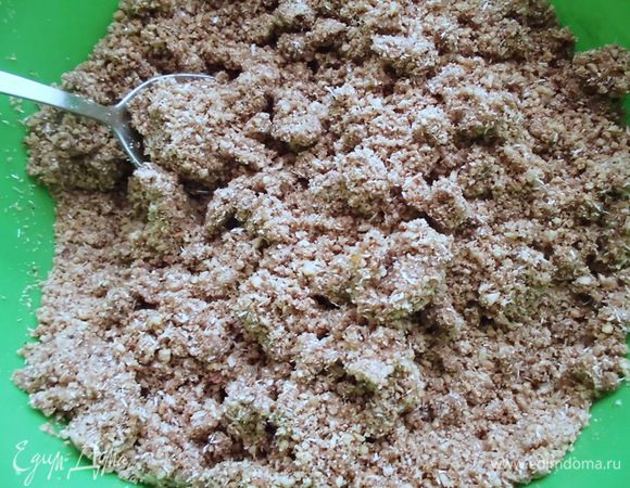 Приготовить основу. Орехи и семечки прокрутить 2 раза через мясорубку (или, как я ее называю, "орехомолку"). Добавить остальные ингредиенты и тщательно перемешать. Воды потребуется несколько ложек. Она нужна тут только для того, чтобы все тщательно соединить.