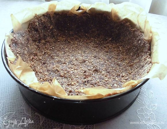 Форму (у меня  20 см) выстелить бумагой для выпечки. Выложить сверху смесь из орехов и семечек, но не всю. Оставить 3-4 ст. л. Сделать бортики.