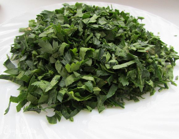 Петрушку хорошо вымыть и обсушить. Отделить зелень от стеблей и мелко нарезать.