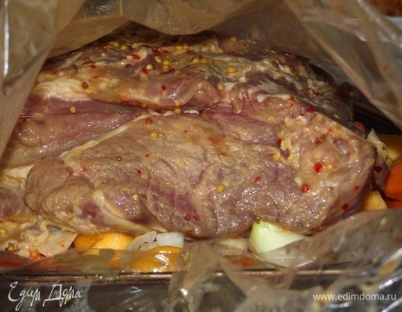 Нагреть духовку до 200 градусов. В пакет для запекания положить морковь, лук, головку чеснока, тимьян, половинку лимона, а сверху выложить мясо. Добавить весь маринад и 100 мл коньяка. Плотно закрываем пакет и отправляем в духовку.
