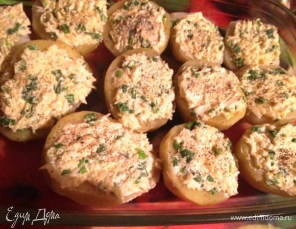 В смазанную маслом форму выложить половинки картофеля и сверху распределить чесночную массу. При желании поперчить.