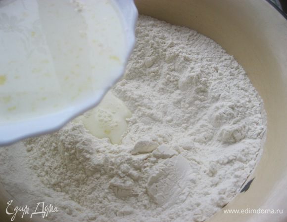 В миску с мукой влить молочную смесь, тщательно перемешать.