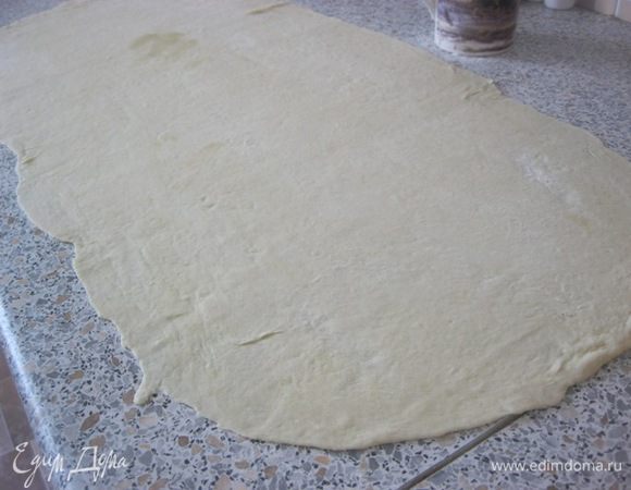 Поверхность присыпать мукой, раскатать тесто очень тонко, в виде прямоугольника, чтобы одна сторона была в два раза больше другой, я раскатала, примерно, 30 на 60 см.
* тесто очень эластичное и не рвется.