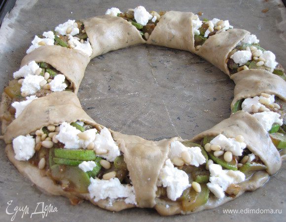 Тесто в середине разрезать на 8 сегментов, сегменты завернуть на пирог и закрепить снизу. Выпекать пирог в заранее разогретой до 180 град. духовке 25 минут.