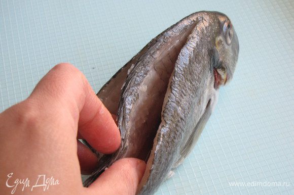 Очистить рыбу от чешуи. Сделать два глубоких разреза вдоль хребта.