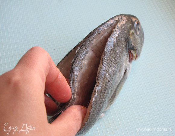 Очистить рыбу от чешуи. Сделать два глубоких разреза вдоль хребта.