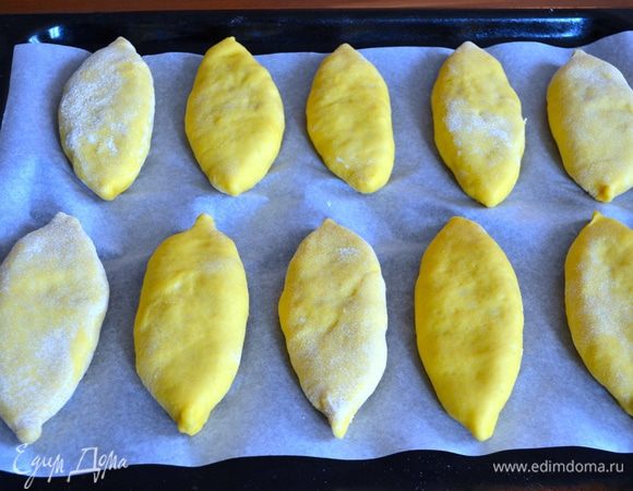 Пирожки выложить на противень, застеленный пекарской бумагой швом вниз. Накрыть полотенцем и дать отдохнуть 15 минут.
Тем временем включить духовку разогреваться на 190°C.