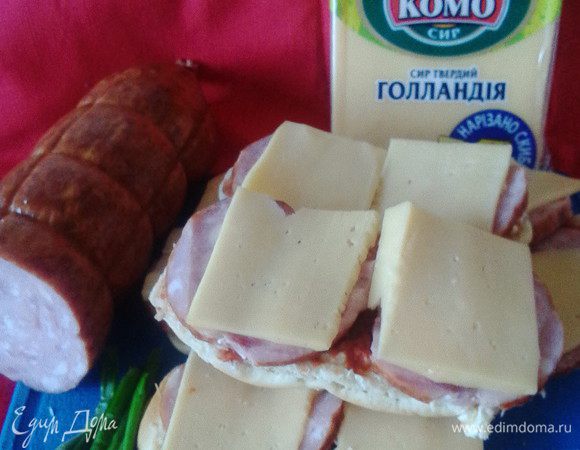 Смазать их кетчупом (у меня домашний с луком), сверху выложить кружочки ветчины (или любой другой колбасы, в т. ч.сосиски, практиковался и праздничный вариант - сырой готовый фарш). Затем посыпать тертым сыром (у меня готовые сырные слайсы). Запекаем в духовке 10-15 минут до характерной румяной сырной корочки.