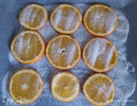Разложить апельсины, сверху присыпать второй половиной сахара. Сушить около часа при 160 градусах, периодически переворачивая. Я еще подъедала образовавшуюся карамель - очень вкусно :-)