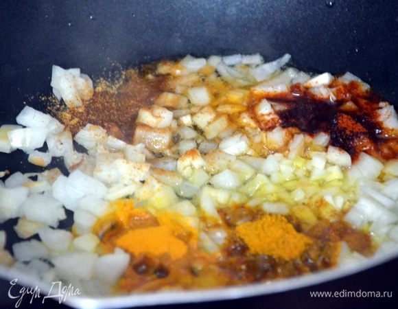 В сковороде разогреваем растительное масло. Нарезаем мелко лук, чеснок. Выкладываем в сковороду, добавляем гарам масалу, карри, паприку, куркуму. Перемешиваем, греем 3-5 минут.