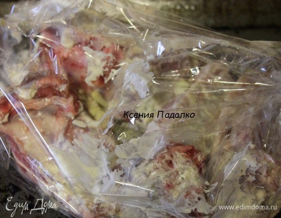 Далее кладем в рукав лук и чеснок, а сверху выкладываем ребра.