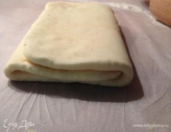 Тесто раскатать в длину таким образом, чтобы длина была в 3 раза больше ширины. Затем мысленно разделить лист на 3 части и сложить конвертом. Завернуть в пищевую пленку и перенести в холодильник на 2 часа.