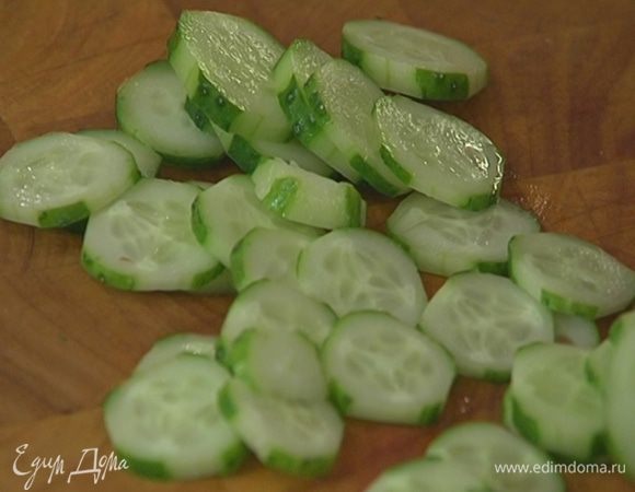С огурцов срезать вдоль часть кожицы, чтобы получились полоски, и нарезать поперек кружками.