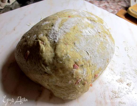 К теплому гороховому пюре добавляем яйцо, вливаем растительное масло, воду (170 мл), вытопившийся от грудинки жир, сушеный лук, базилик, чеснок и соль. Размешиваем. Всыпаем цельнозерновую муку, дрожжи, и просеиваем через сито пшеничную муку. Если у вас есть хлебопекарный улучшитель "Панифреш" или "Панифарин", то добавьте одну столовую ложку. 

Начинаем замешивать тесто. Добавляем грудинку и продолжаем месить. Тесто получается довольно густое. После замеса накрываем тесто полотенцем и ставим "отдохнуть" в теплое место на час.

Если у вас есть хлебопечь, эту часть работы вы можете спокойно доверить ей. Режим "тесто" 1,5 часа.