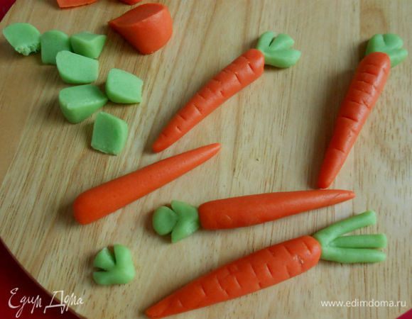 Разберите на сегменты и из оранжевых скатайте конусы, а из зеленых сделайте сплюснутые треугольники или скатайте жгутики. Неострым ножом сделайте произвольно поперечные отметины на морковках. Зеленые лепешечки разделите ножом на 3 сегмента в виде листочков. Если есть время и желание, листочки можно сделать более объемными. Конечно, у моркови нет таких листочков, но что-то зеленое должно быть на пироге!)