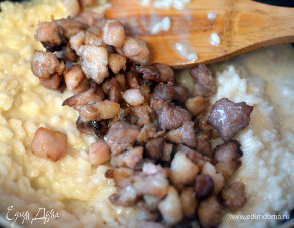 В яичный соус добавляем половник горячего бульона, тщательно размешиваем. Выливаем соус в сковороду с рисом. Туда же добавляем обжаренную свиную щековину. Все тщательно перемешиваем снова, все готово, можно подавать!!!

Выкладываем ризотто в тарелку и постукиваем пальцами по ее дну (активно, но аккуратно), чтобы ризотто равномерно "растекся". Присыпаем свежемолотым перцем.