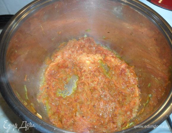 Добавляем натертую морковь и обжариваем до золотистого цвета. Выдавливаем чеснок. Ошпариваем помидоры и снимаем кожуру. Нарезаем кубиками и добавляем к луку с морковью, чуть обжариваем.