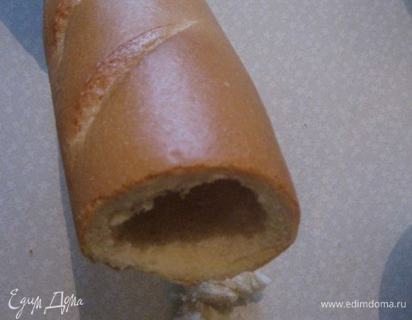Отрезать кончики багета. Из багета вынимаем мякиш. Длинным ножом внутри, с двух сторон вокруг вырезаем. Потом я толкнула мякиш, тупым концом ножа и он выпал на стол. Мякиш нарезаем маленькими квадратиками.