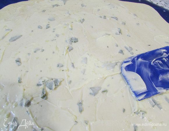 Когда тесто увеличится в объеме, его нужно осадить и тонко раскатать. Затем смазать чесночным маслом.