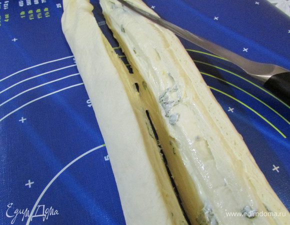 Разрезать рулет вдоль пополам, получив два жгута.