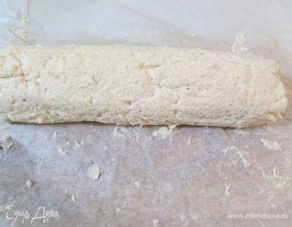 Выложите фарш на пекарскую бумагу. С помощью бумаги сформируйте рулет. 