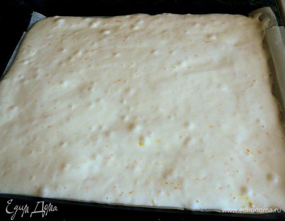 Смешать просеянную муку с крахмалом, разрыхлителем и цедрой апельсина и, в несколько приемов добавить к яичной смеси. Размешивать ложкой снизу вверх, методом складывания. Противень застелить бумагой для выпечки, смазать маслом, вылить тесто и равномерно распределить его.