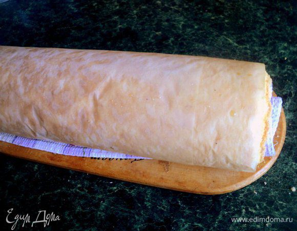 Выпекать при температуре 180 градусов 15-20 минут до легкого зарумянивания. Готовый бисквит накрыть полотенцем и, не снимая бумагу для выпечки, свернуть рулетом. Охладить.