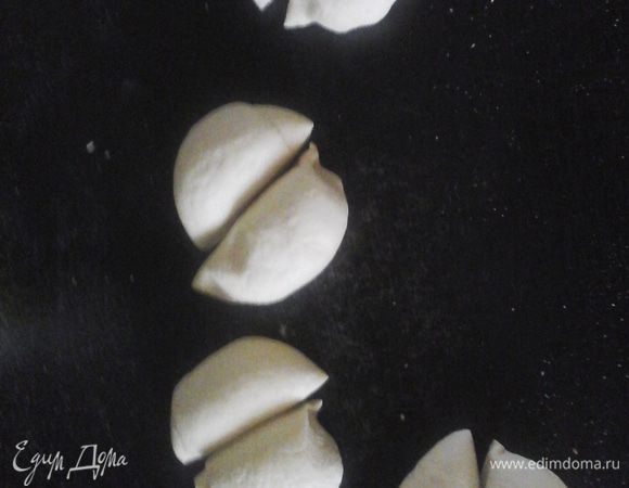 Шар разрезать на пополам, сделать два шара. Каждый шар разрезать на 4 части, сделать шарики и выложить на противень (всего 8), слегка приплюснуть, накрыть полотенцем и оставить на 40 минут в теплом месте.