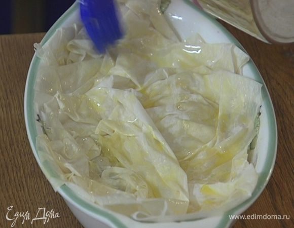 Листы теста фило слегка скомкать, смазать растопленным сливочным маслом и накрыть ими сверху грибы, уложив один на другой.