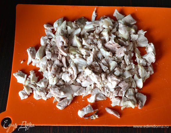 Из готового бульона достать бедрышки и нарезать помельче очищенные с костей кусочки мяса. Отложить в сторону. 