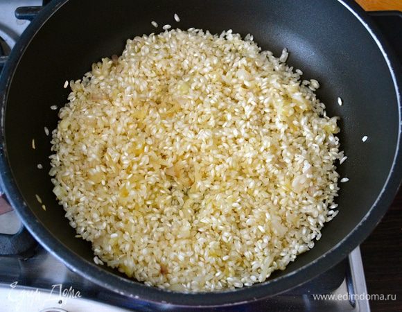 Добавить в сковороду рис. Предварительно не промывать! В данном рецепте используется рис сорта Бальдо (Baldo), за отсутствием этого сорта, можно использовать рис карнароли. Перемешать рис с луком и дать обжариться буквально пару минут, помешивая. 