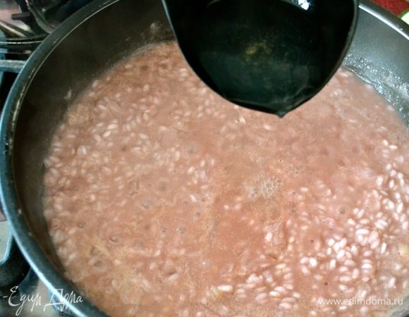 Добавить горячий (!) куриный бульон. Продолжать готовить ризотто, подливая горячий бульон по мере того, как он будет впитываться, помешивая, до готовности ризотто (около 16 минут).