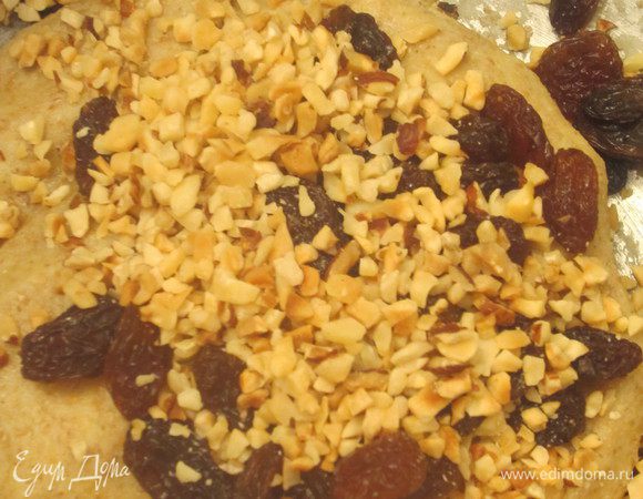 В тесто добавляем изюм и фундук, перемешиваем.