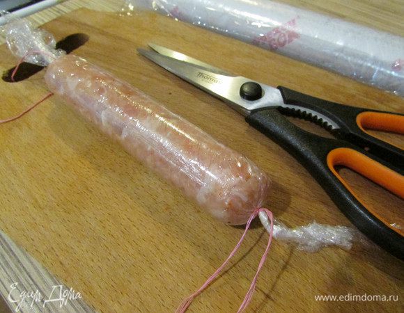 Туго завернуть фарш в несколько слоев пленки, формируя сосиску, края завязать ниткой. 