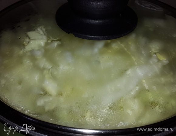 Добавляем капусту, наливаем немного воды, накрываем крышкой и убавляем огонь до минимума, тушим до мягкости капусты.