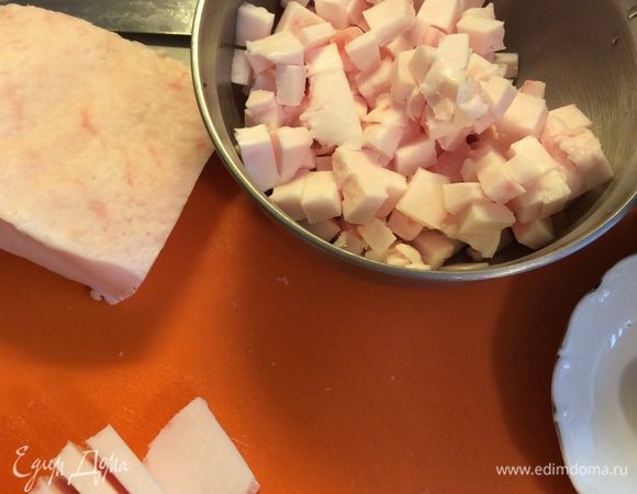 Одновременно нарезаем сало кусочками как на салат Оливье и выпаливаем на сковороде. Дополнительно нарезаем сало прямоугольными кусочками. После того, как сало вытопилось на этом жире жарим свинину. После добавляем сметану в сковороду. Получается достаточно жирная подлива. 