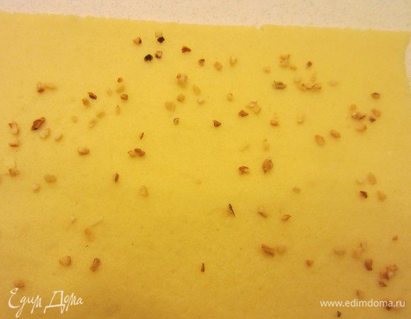 Рабочую поверхность посыпаем мукой. Раскатываем наши шарики теста толщиной в 5 мм, но не очень тонко. По желанию можно посыпать орешками.