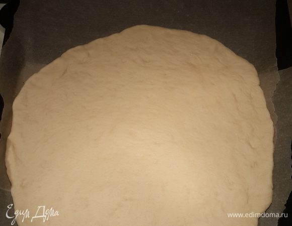 Противень застелить пергаментной бумагой. Смазываем её маслом. Раскатываем тесто очень тонко. Чем тоньше оно будет раскатано, тем хрустящее получится корочка. Диаметр пиццы 35-40 см в идеале. Мой противень не дал мне такой возможности. Сейчас то я понимаю, что легко могла сделать 2 тоненьких пиццы из этого кол-ва теста. Ну да ладно, в следующий раз поступлю так.
Перекладываем лепёшку на противень