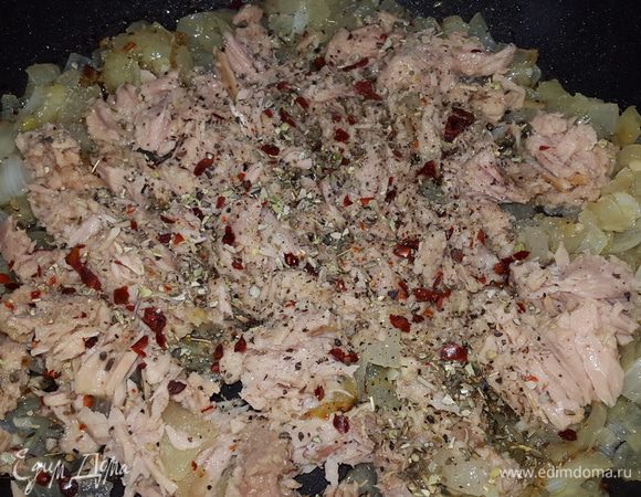К луку с чесноком добавляем тунец, солим, перчим, посыпаем травами, перемешиваем и прогреваем 2-3 минуты.