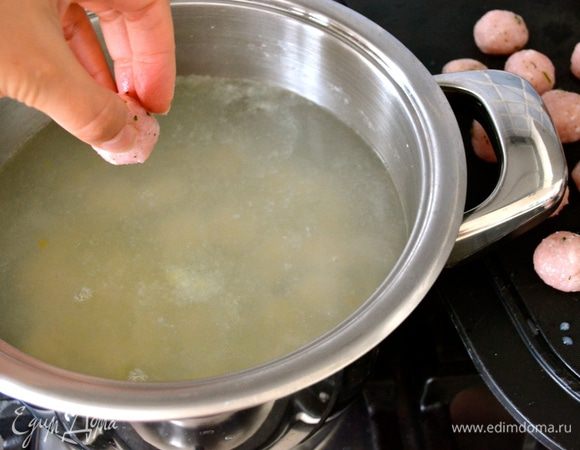 Подготовленные тефтельки осторожно выложить в кипящую воду, время от времени осторожно перемешивая, чтобы они не прилипли, пока Вы выкладываете их в кастрюлю. Посолить. 