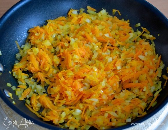 Тем временем в сковороде разогреть 2 ложки оливкового масла и слегка обжарить лук и морковь до размягчения овощей.  