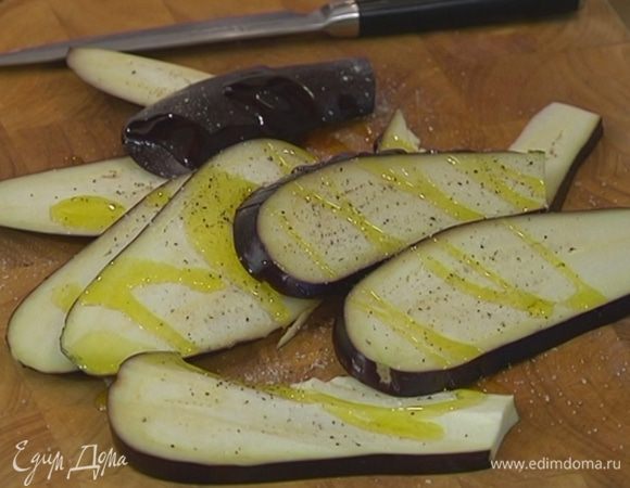 Баклажаны нарезать вдоль пластинами, посолить, поперчить и смазать оливковым маслом.