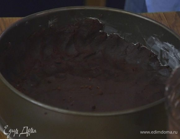 Дно разъемной формы для выпечки выстелить пищевой бумагой, смазать бумагу и стенки формы оставшимся сливочным маслом и равномерно выложить тесто, сформировав невысокие тонкие бортики.